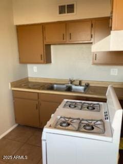 104 N Casa Grande Ave, Casa Grande, AZ 85122 - kitchen featuring white gas range oven, a sink, visible vents, baseboards, and dark tile patterned flooring