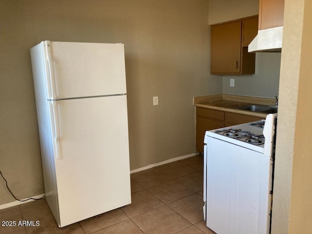 104 N Casa Grande Ave, Casa Grande, AZ 85122 - kitchen with a sink, white appliances, light countertops, under cabinet range hood, and light tile patterned floors