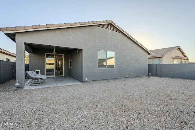 back house at dusk with a patio