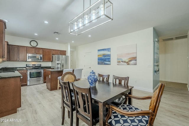 dining room featuring sink and light hardwood / wood-style flooring