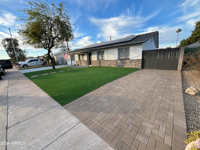 view of front facade with a front lawn and solar panels