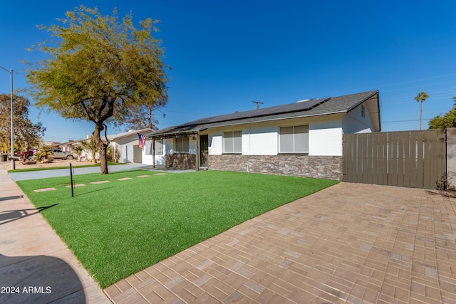 exterior space featuring a front yard, solar panels, and a garage