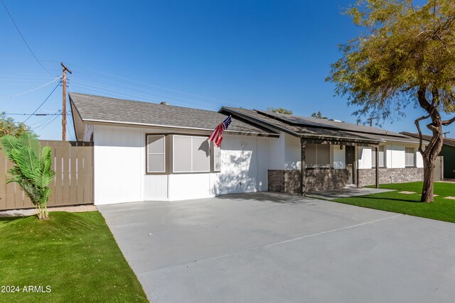 view of front of home with a front lawn and solar panels