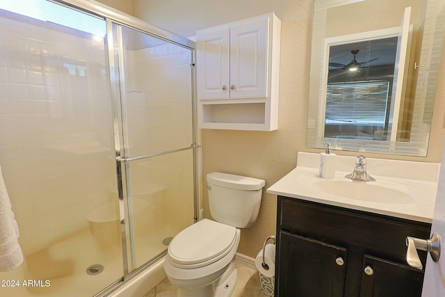 bathroom featuring ceiling fan, tile patterned floors, toilet, a shower with door, and vanity