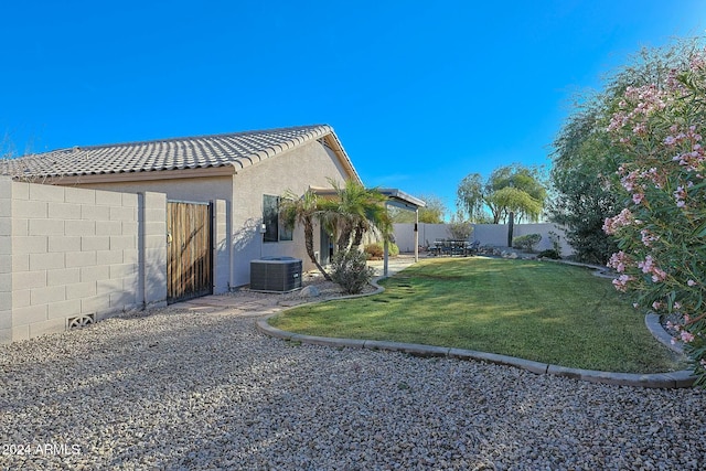 view of property exterior with a lawn and cooling unit