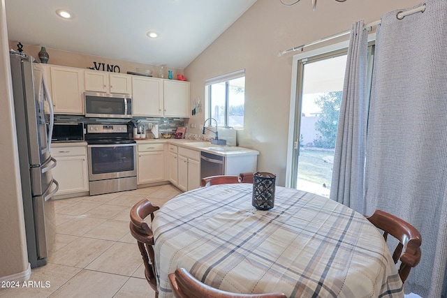 kitchen featuring white cabinets, sink, decorative backsplash, light tile patterned floors, and appliances with stainless steel finishes