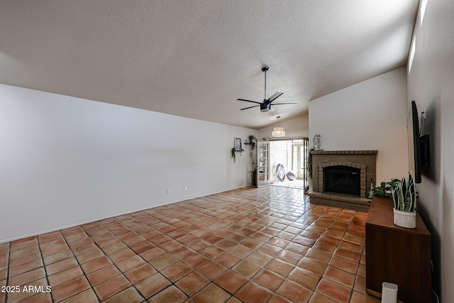 unfurnished living room featuring lofted ceiling, a textured ceiling, ceiling fan, a fireplace, and tile patterned flooring