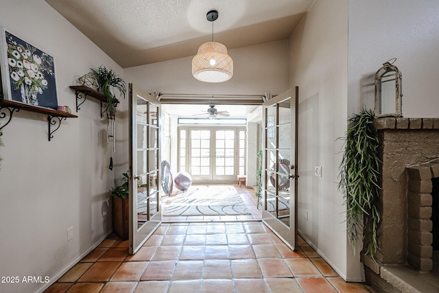 doorway featuring light tile patterned floors, vaulted ceiling, french doors, and a textured ceiling