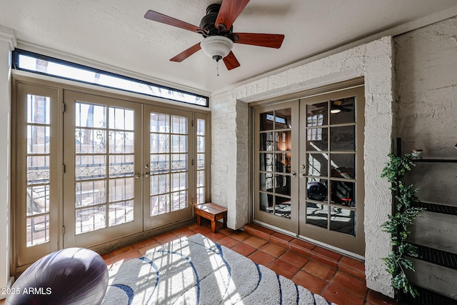 entryway with french doors, ceiling fan, and dark tile patterned flooring