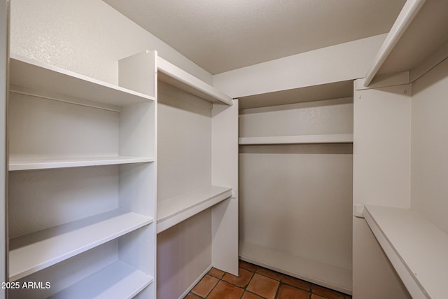 spacious closet with dark tile patterned floors