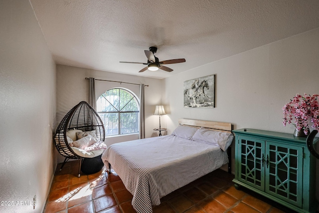 bedroom with ceiling fan and a textured ceiling