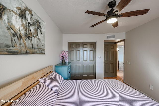 unfurnished bedroom featuring a textured ceiling, ceiling fan, and a closet