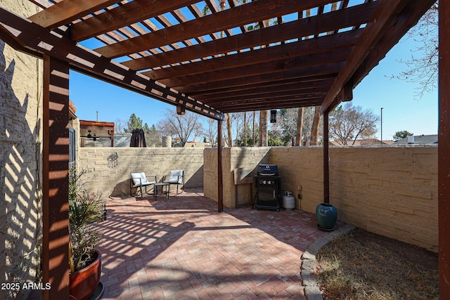 view of patio with area for grilling and a pergola