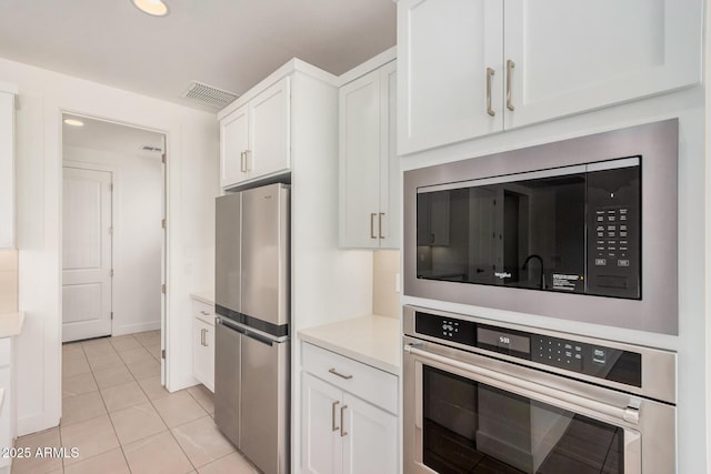 19354 S 212th Pl, Queen Creek, AZ 85142 - kitchen with stainless steel appliances, white cabinetry, light countertops, light tile patterned floors, and recessed lighting