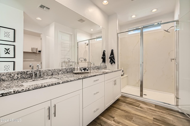 bathroom with vanity, hardwood / wood-style flooring, and walk in shower