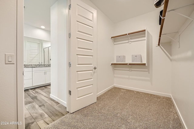 walk in closet featuring light carpet