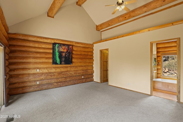 spare room featuring rustic walls, beamed ceiling, and carpet floors