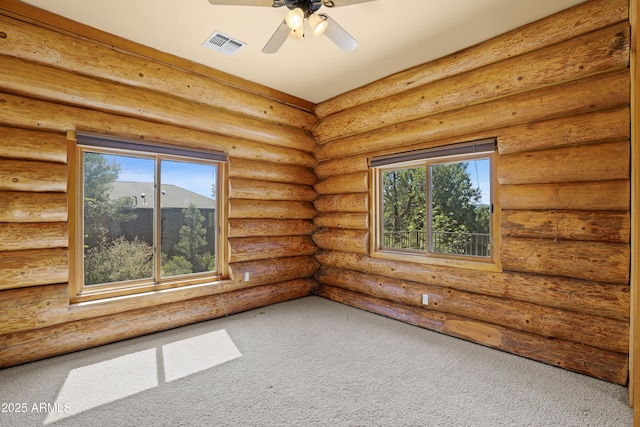 unfurnished room with carpet, plenty of natural light, visible vents, and a ceiling fan