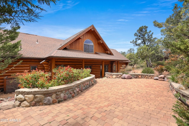 log-style house with a shingled roof and log exterior