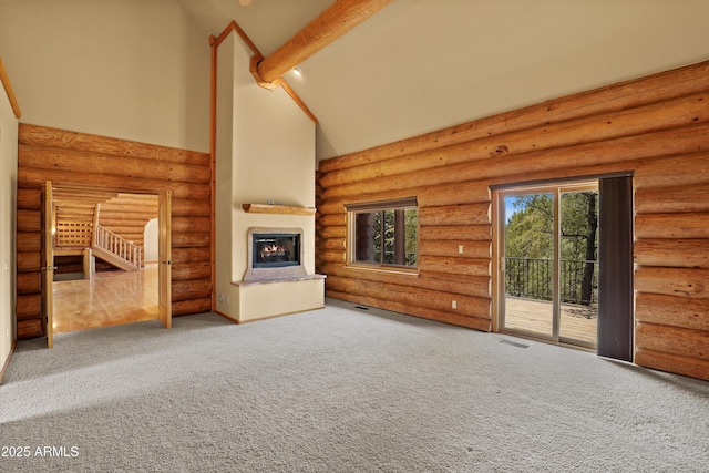 unfurnished living room with carpet flooring, visible vents, high vaulted ceiling, a lit fireplace, and beamed ceiling