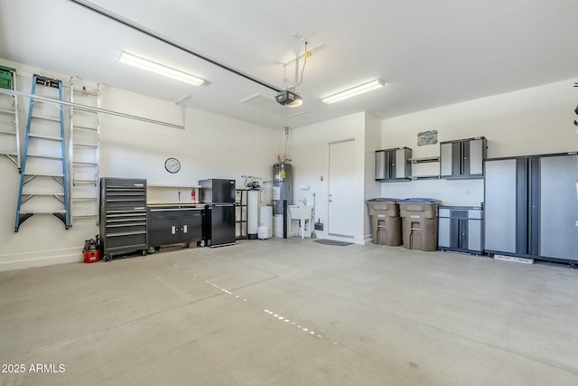 garage featuring black refrigerator, a garage door opener, sink, and secured water heater