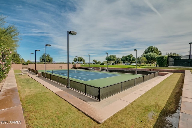 view of tennis court with a yard