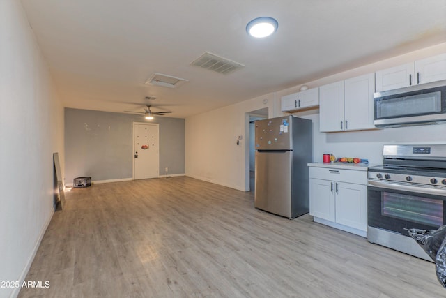 2608 W Pierson St, Phoenix, AZ 85017 - kitchen with appliances with stainless steel finishes, light wood-style flooring, light countertops, white cabinetry, and open floor plan