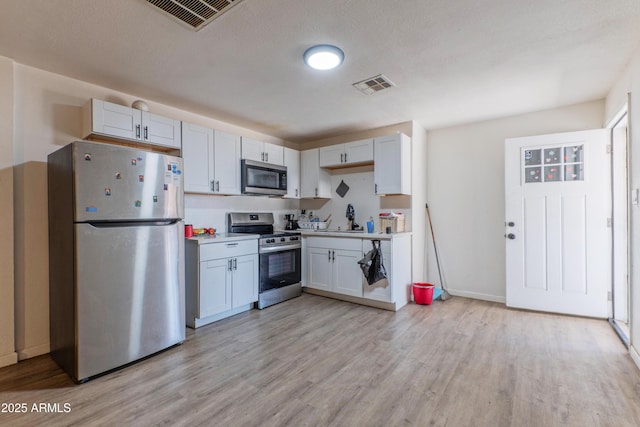 2608 W Pierson St, Phoenix, AZ 85017 - kitchen with stainless steel appliances, light wood-style flooring, light countertops, and white cabinetry