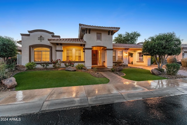 mediterranean / spanish-style home with a front yard