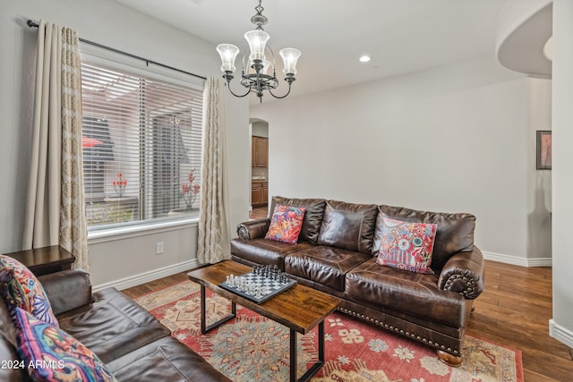 living room featuring a chandelier and dark wood-type flooring