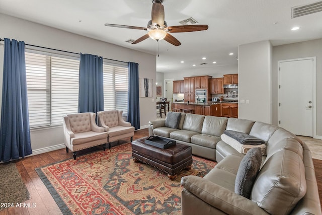 living room with dark hardwood / wood-style flooring and ceiling fan