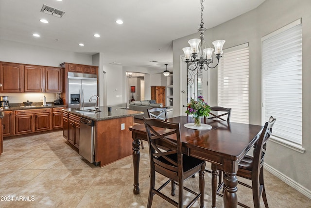 tiled dining area featuring sink and ceiling fan with notable chandelier