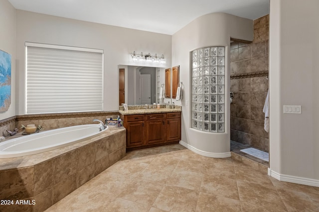 bathroom with tile patterned flooring, vanity, and shower with separate bathtub