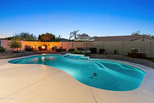 view of swimming pool with pool water feature and a patio