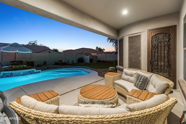 pool at dusk featuring a patio