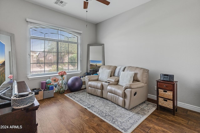 living area featuring ceiling fan and dark wood-type flooring