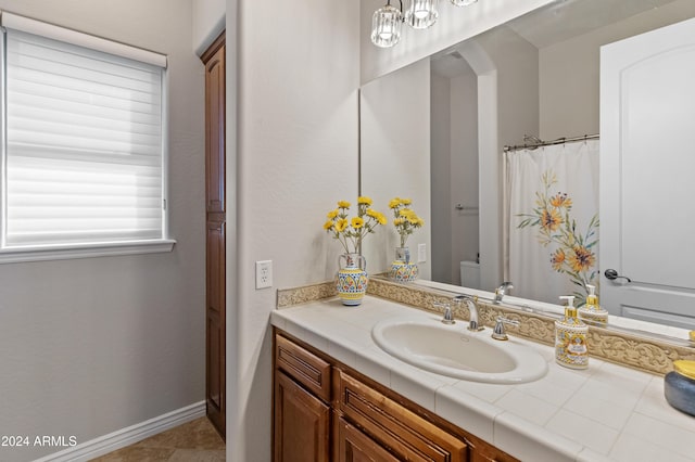 bathroom with tile patterned flooring, vanity, and toilet