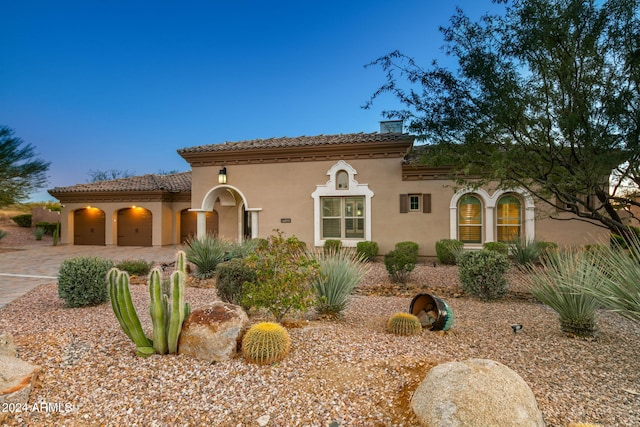 mediterranean / spanish home featuring a garage