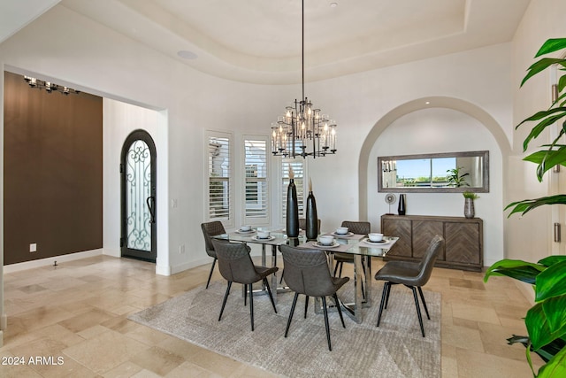 dining area featuring an inviting chandelier and a tray ceiling