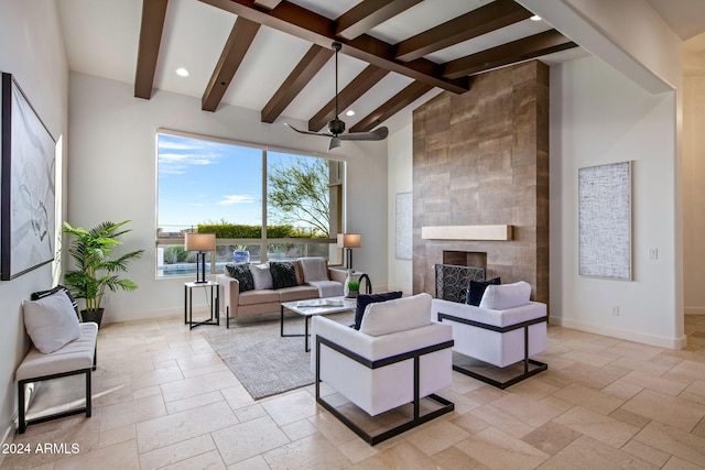 living room featuring beamed ceiling, ceiling fan, a fireplace, and high vaulted ceiling