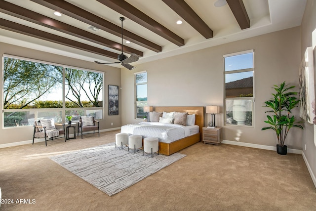 bedroom featuring beamed ceiling, ceiling fan, and light colored carpet