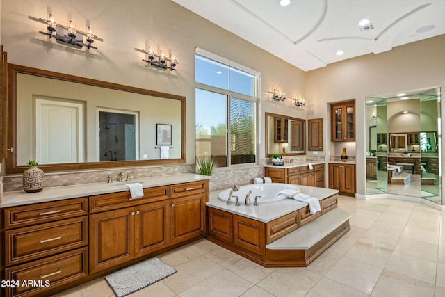 bathroom with tile patterned flooring, a bath, and vanity