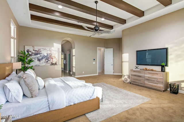 bedroom featuring beam ceiling, ceiling fan, and light colored carpet