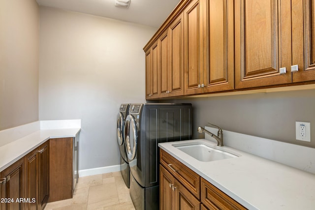 laundry room featuring cabinets, sink, and washing machine and clothes dryer