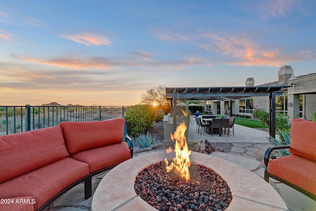 patio terrace at dusk featuring a pergola and an outdoor living space with a fire pit