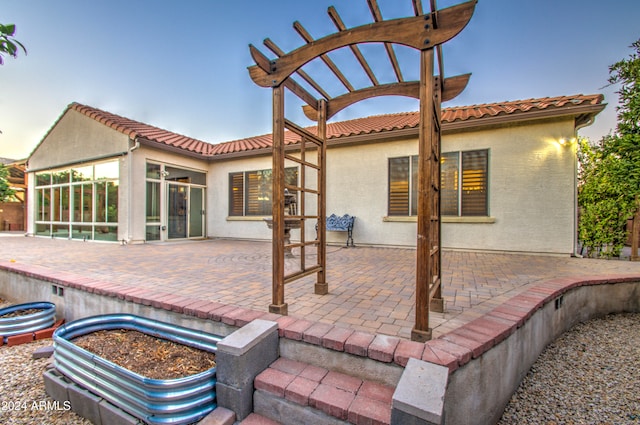 patio terrace at dusk featuring a pergola