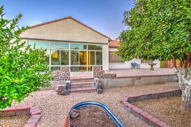 back of house with a sunroom and a patio area