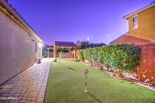 yard at dusk featuring a patio and a gazebo