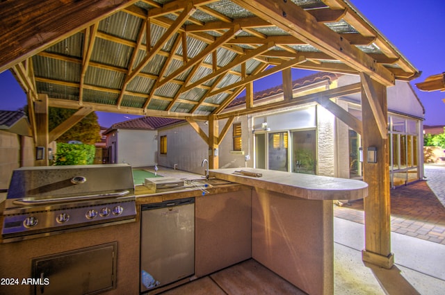 patio terrace at dusk featuring area for grilling and a grill