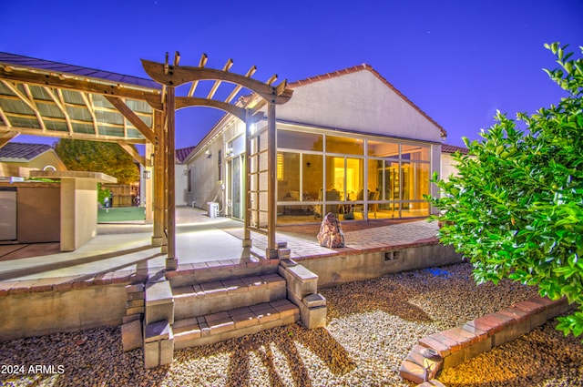 back of house featuring exterior kitchen, a pergola, a sunroom, and a patio area